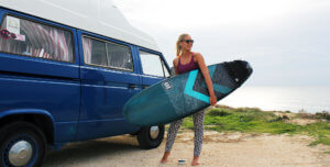 surfer girl with surf board getting ready to surf, vw campervan, ocean