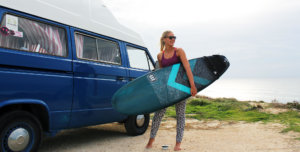 Girl in surf holidays with campervan