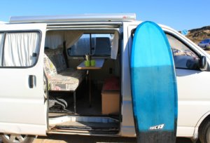 Campervan and surfboard for surf holidays