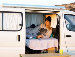 Girl chill with sunset view inside campervan in surf holidays