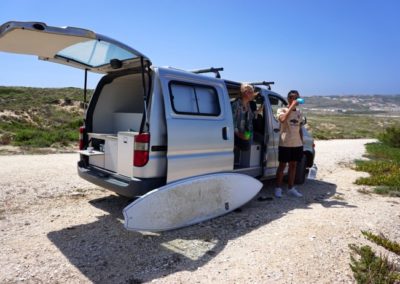 Young travelers enjoying a surf session with Atlantic Coast Campers' Ginginha campervan in Portugal.